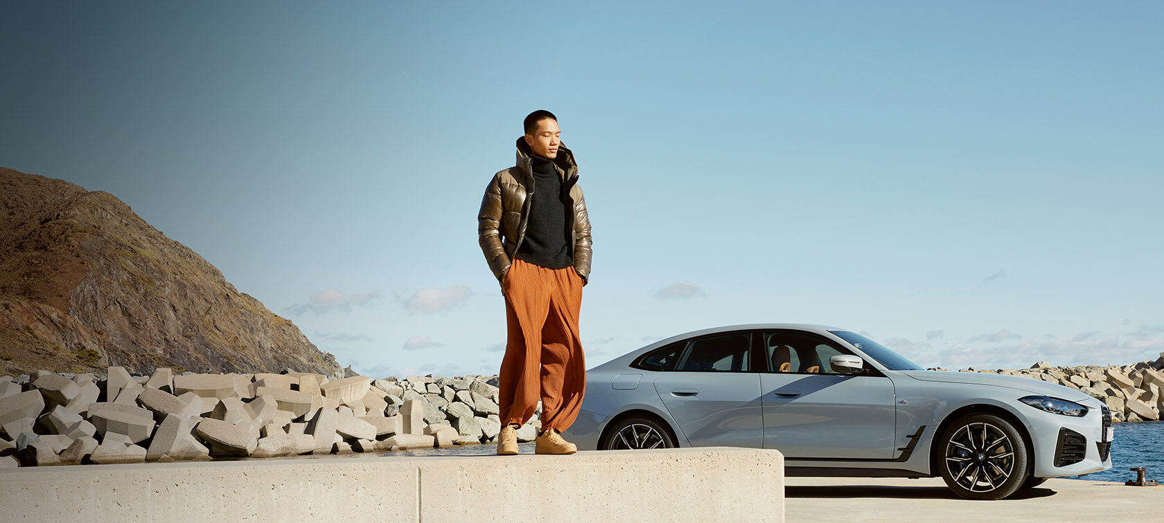 BMW Service Inclusive BMW Service Inclusive мъж пред BMW i4 на брега