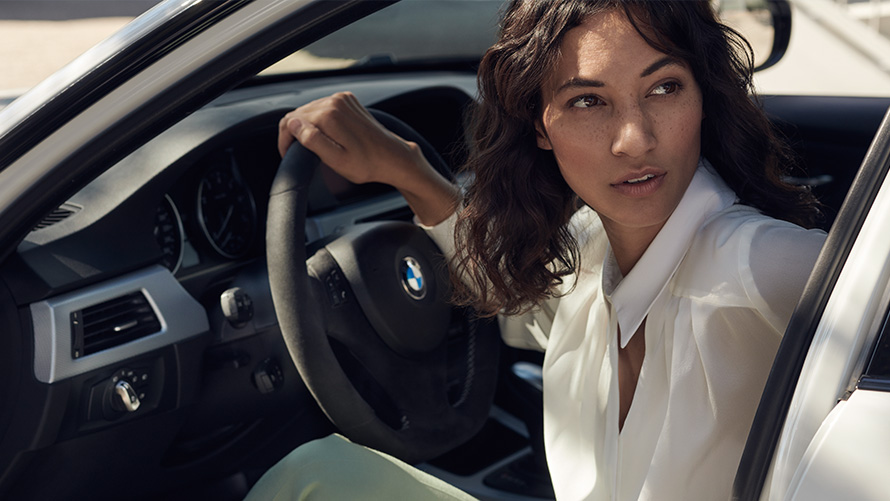 BMW Value Service Клиентка на BMW Сервиз гледа през отворената врата на своето BMW