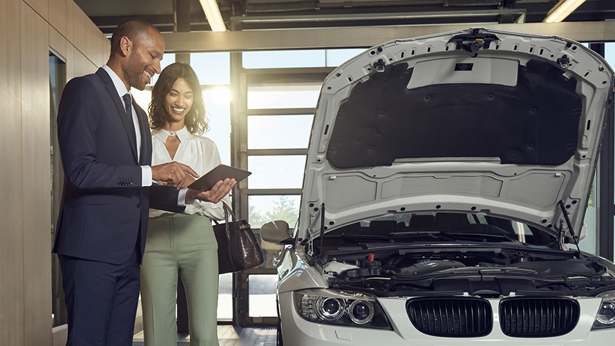 Преглед и техническо обслужване Клиент на BMW Сервиз и служители на BMW Сервиз обсъждат преглед и техническо обслужване