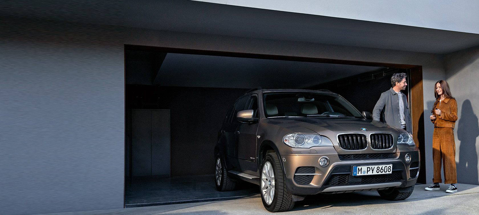BMW Value Service BMW Value Service мъж и жена пред гараж с BMW X5